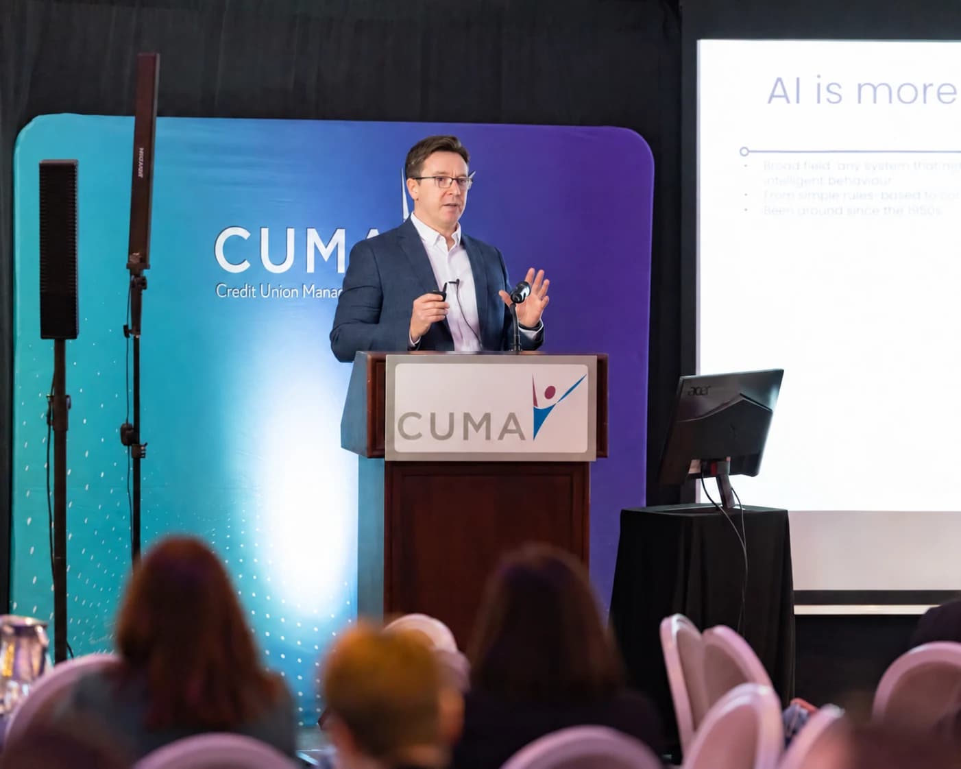 Paul Ferguson speaking to a conference audience from a lectern